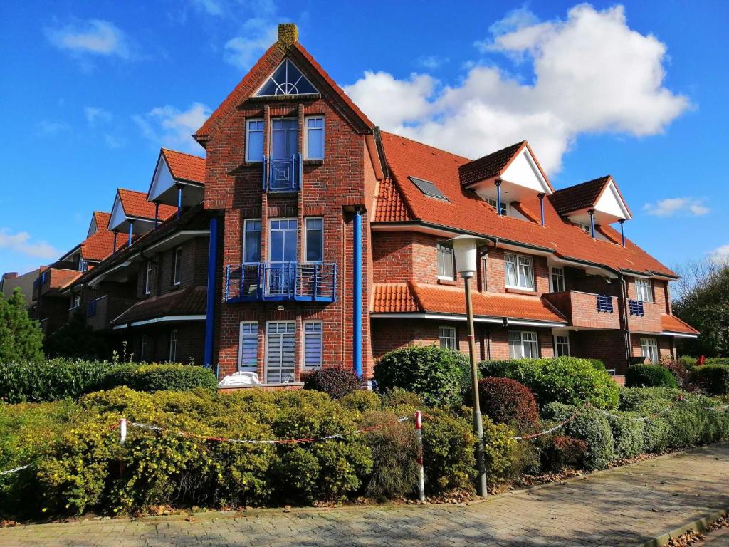 a large brick building with a red roof at Ferienwohnung Boje 5 in Schillig