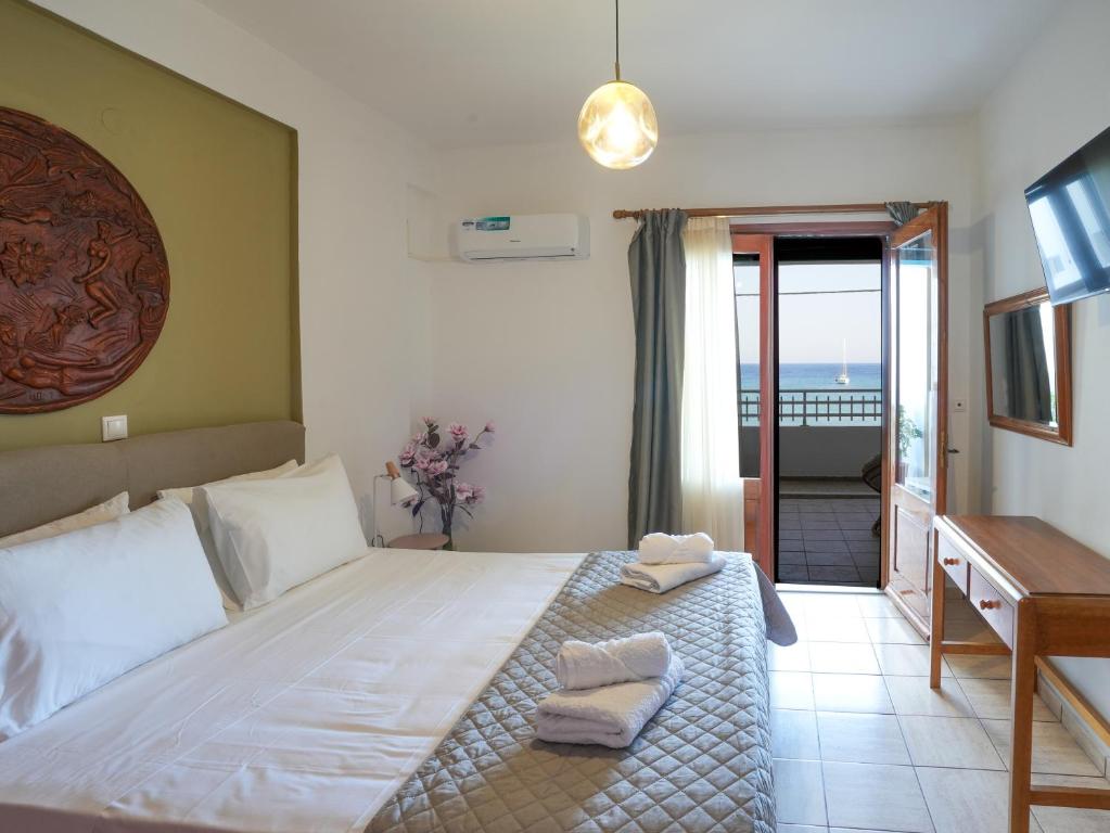a bedroom with a bed and a desk and a television at Theodora Suite by Pegasus in Kardamaina