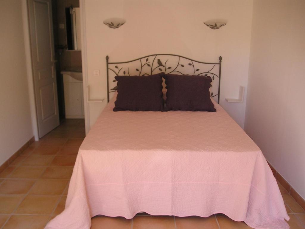 a bedroom with a pink bed with a black headboard at E Stelle di A Bella Vista in Bonifacio