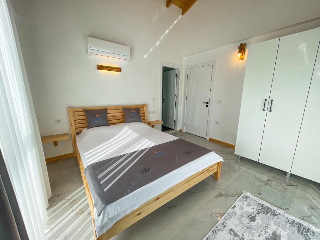 una camera da letto con un letto grande in una stanza di Villaderyadeniz a Kızılyaka