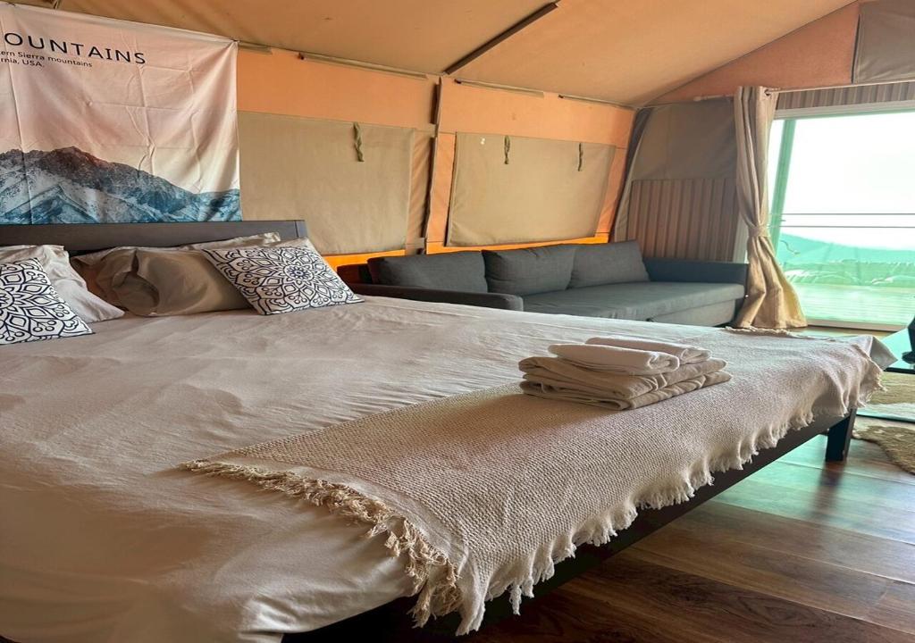 a bed in a tent with two towels on it at Taara Montana Resort in Ban Huai Khai