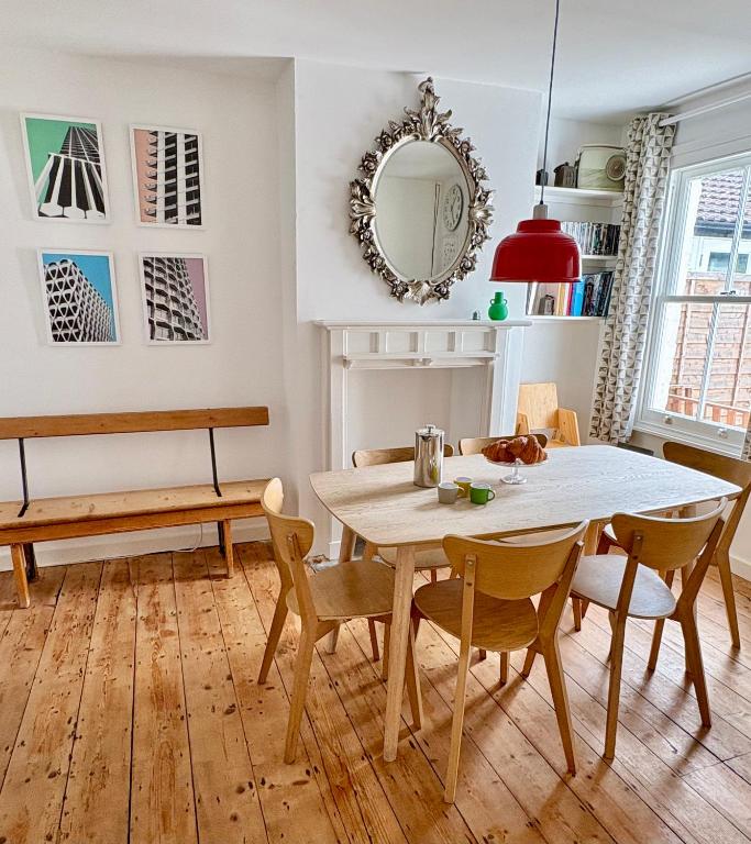 a dining room with a table and chairs and a mirror at Stylish Victorian Cottage, 2mins from Whitstable Harbour & Shops in Whitstable