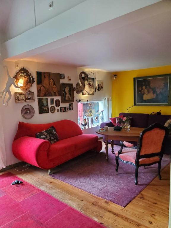 un salon avec un canapé rouge et une table dans l'établissement Artist's house for rent, à Guérande