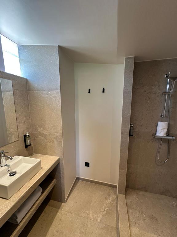 a bathroom with a sink and a white door at Hôtel Le Médiéval Palais des Papes in Avignon