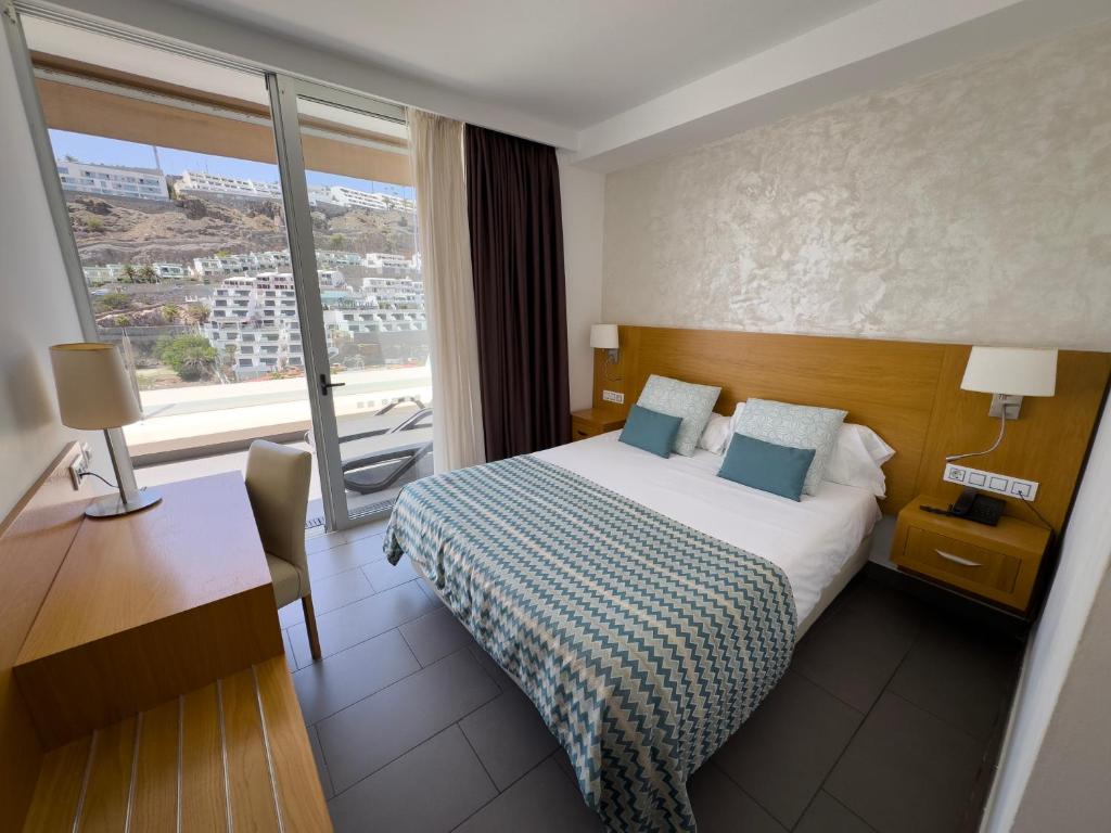 a hotel room with a bed and a window at Holiday Club Puerto Calma in Puerto Rico de Gran Canaria