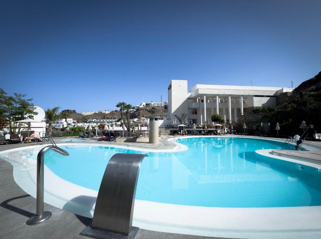 a large blue swimming pool in front of a building at Holiday Club Puerto Calma in Puerto Rico de Gran Canaria