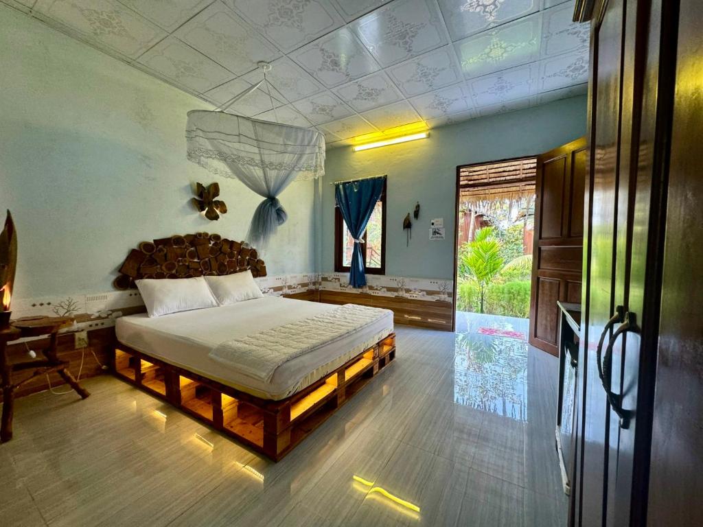 a bedroom with a large bed in a room at Muong Dinh Lodge in Ấp Nhơn Bình