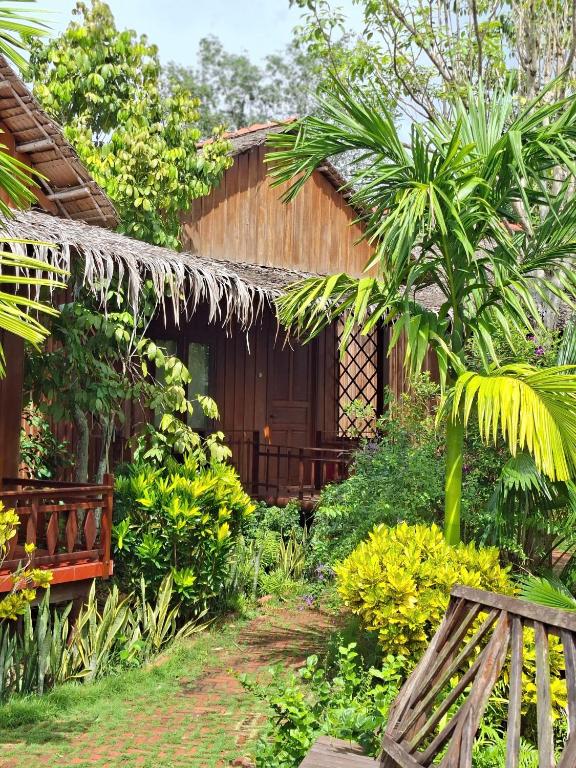 a house with a bench in front of it at Muong Dinh Lodge in Ấp Nhơn Bình