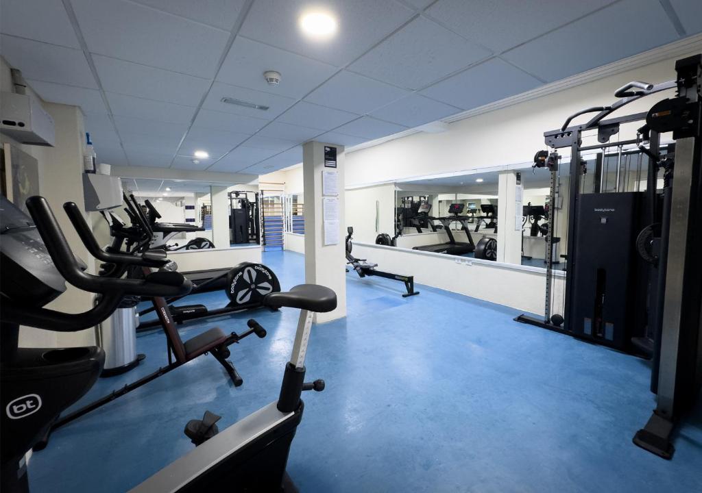 a gym with several tread machines and a mirror at Holiday Club Puerto Calma in Puerto Rico de Gran Canaria