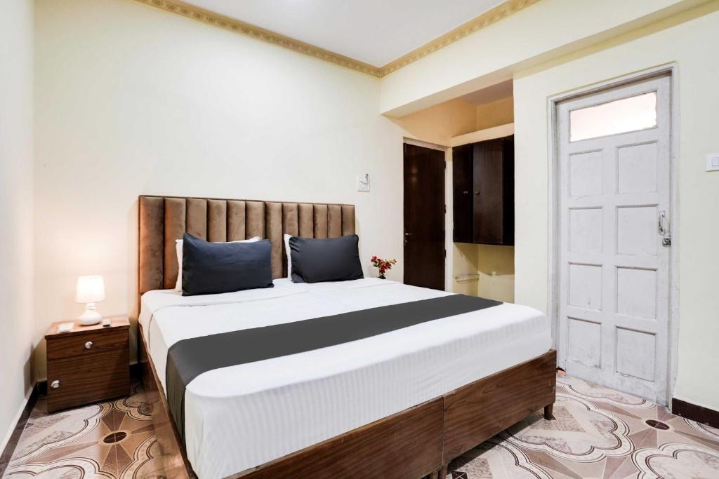 - une chambre avec un grand lit et une porte dans l'établissement Hotel O Calangute, à Goa