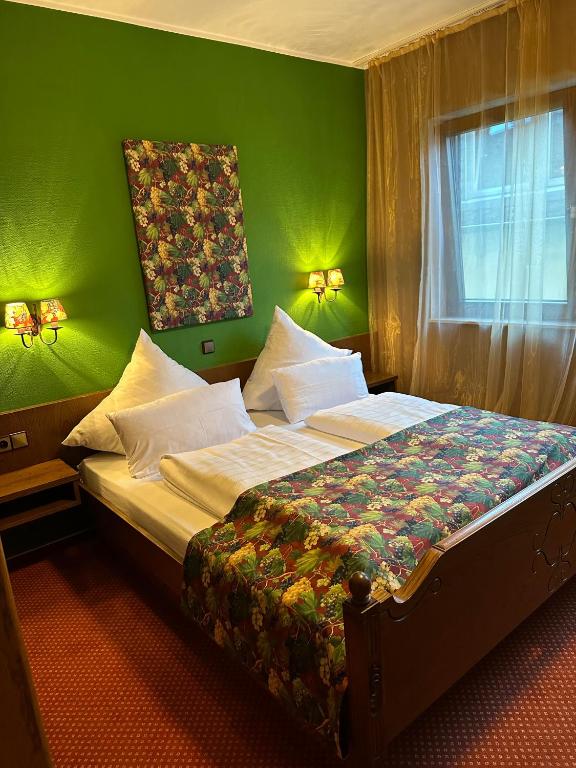 a bedroom with a large bed with a green wall at Lesura Ferien- Apartment in Lieser