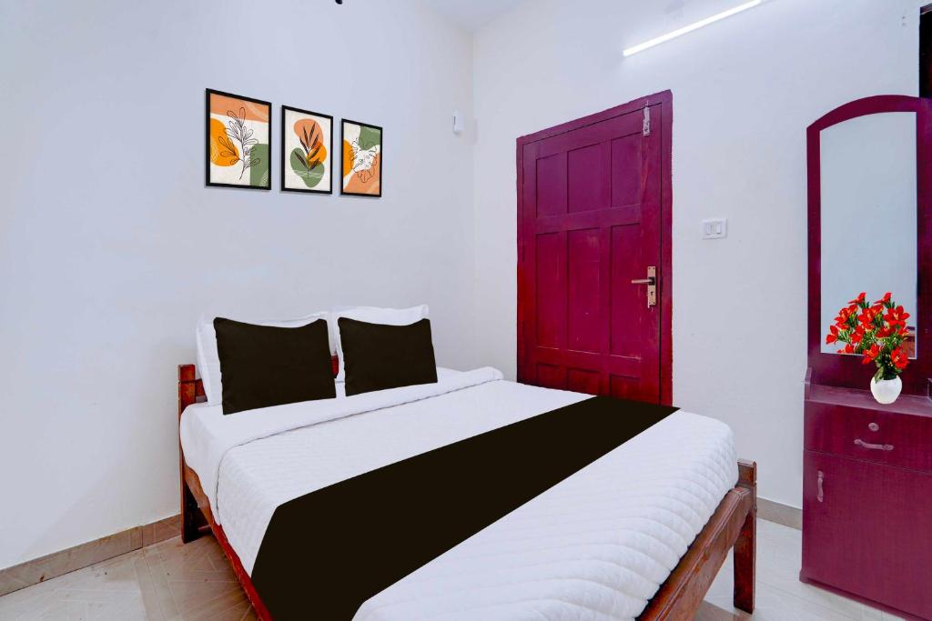 1 dormitorio con 1 cama con puerta roja en Hotel O Kunchithanny Road Munnar, en Munnar