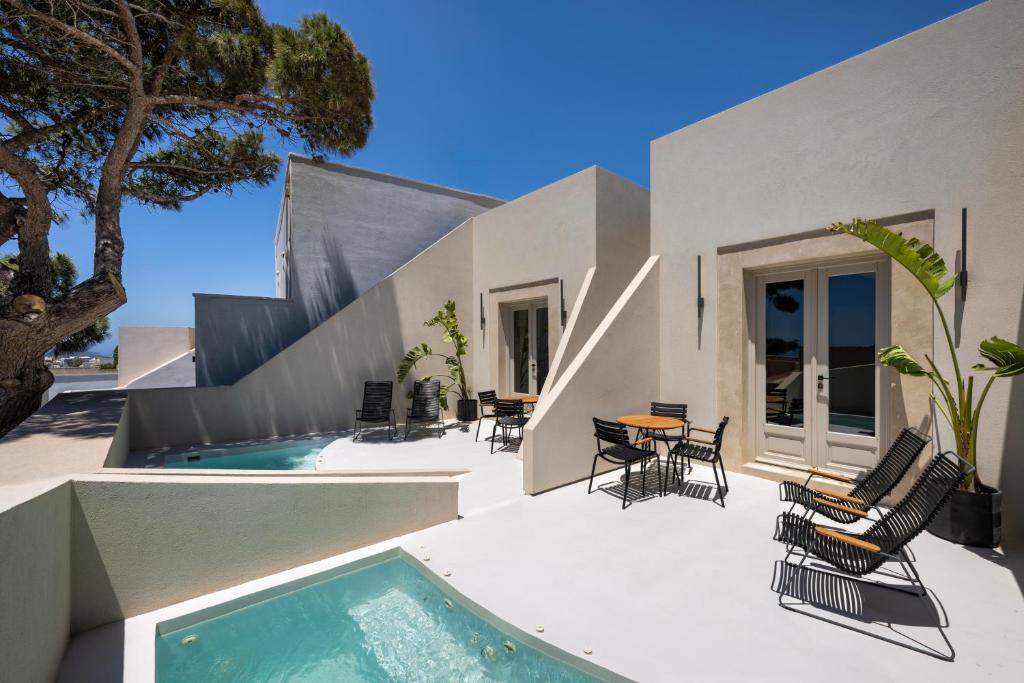 een patio met stoelen en een zwembad naast een huis bij Calissa Suites by Ananda in Pirgos