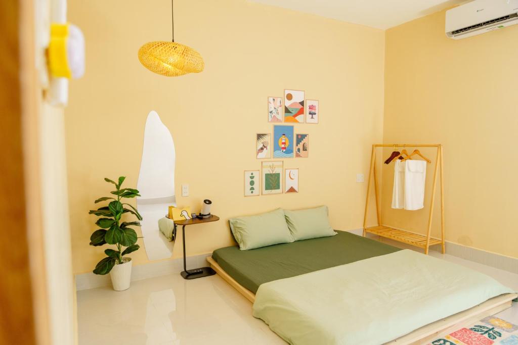 a bedroom with a bed and a potted plant at Morri Homestay in Rach Gia