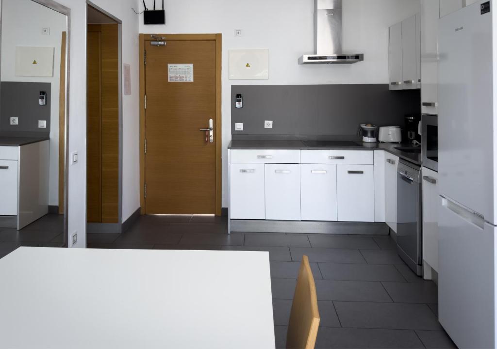 a kitchen with white cabinets and a brown door at Holiday Club Puerto Calma in Puerto Rico de Gran Canaria