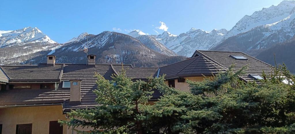 a house with mountains in the background at Apartment with terrace close to the slopes in Le Monêtier-les-Bains