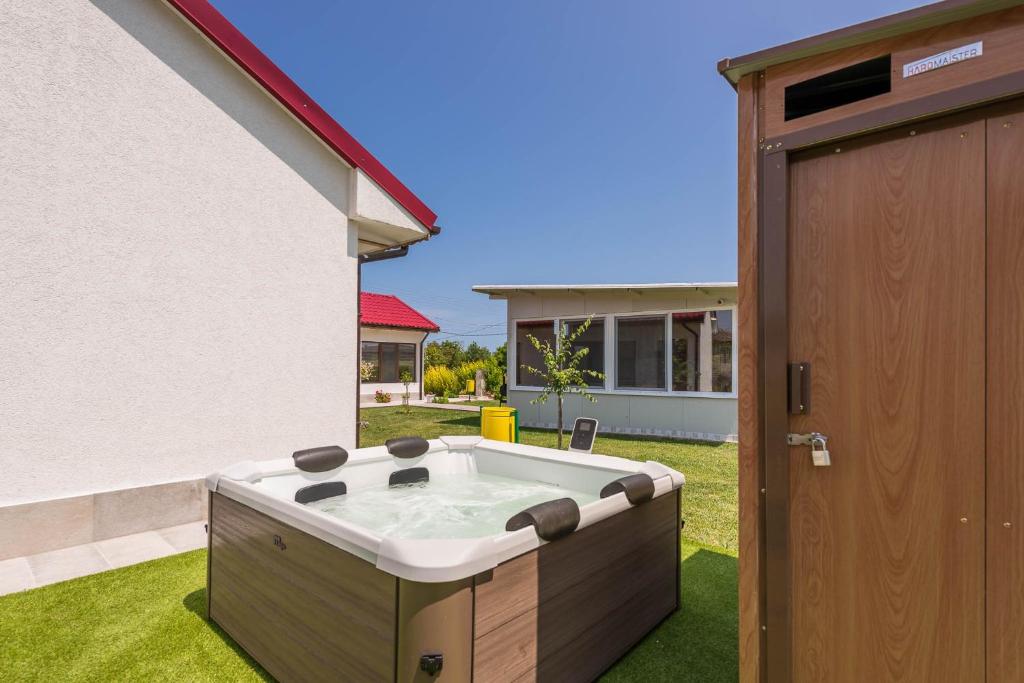 a hot tub in a yard next to a house at Sea Breeze Vacation House I BBQ & Jacuzzi in Ezerets