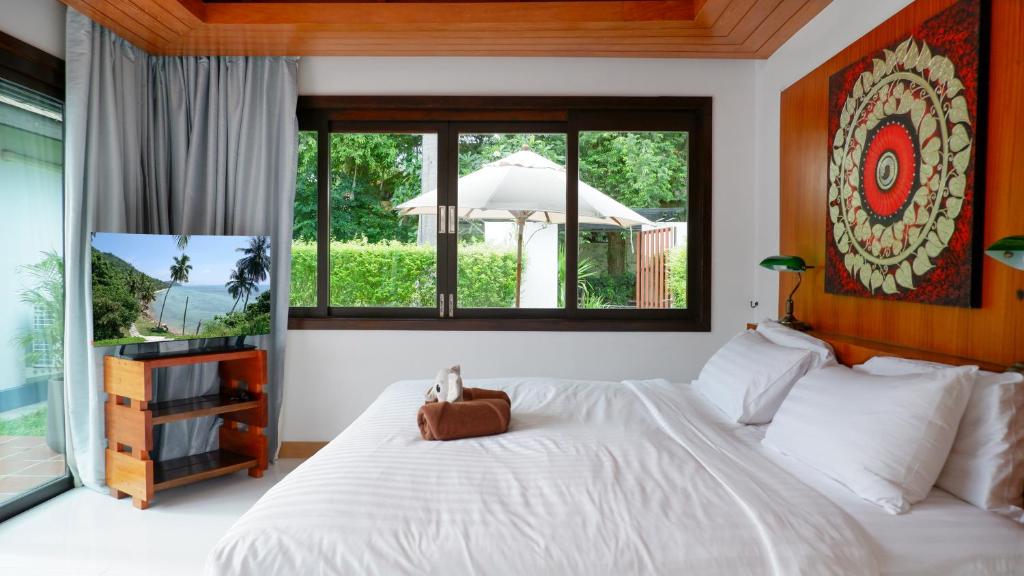 a bedroom with a large white bed and a window at MAKALA Pool Villa in Choeng Mon Beach
