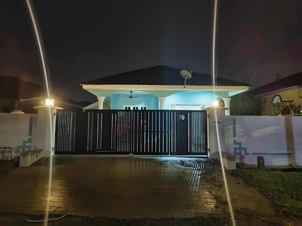 a house with a black gate at night at Rumah Pak Syed in Ipoh