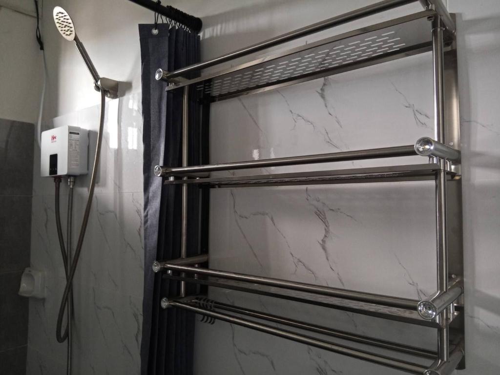 a bathroom with a towel rack and a shower at Affordable Room in Calamba - Rm 2 in Bukal