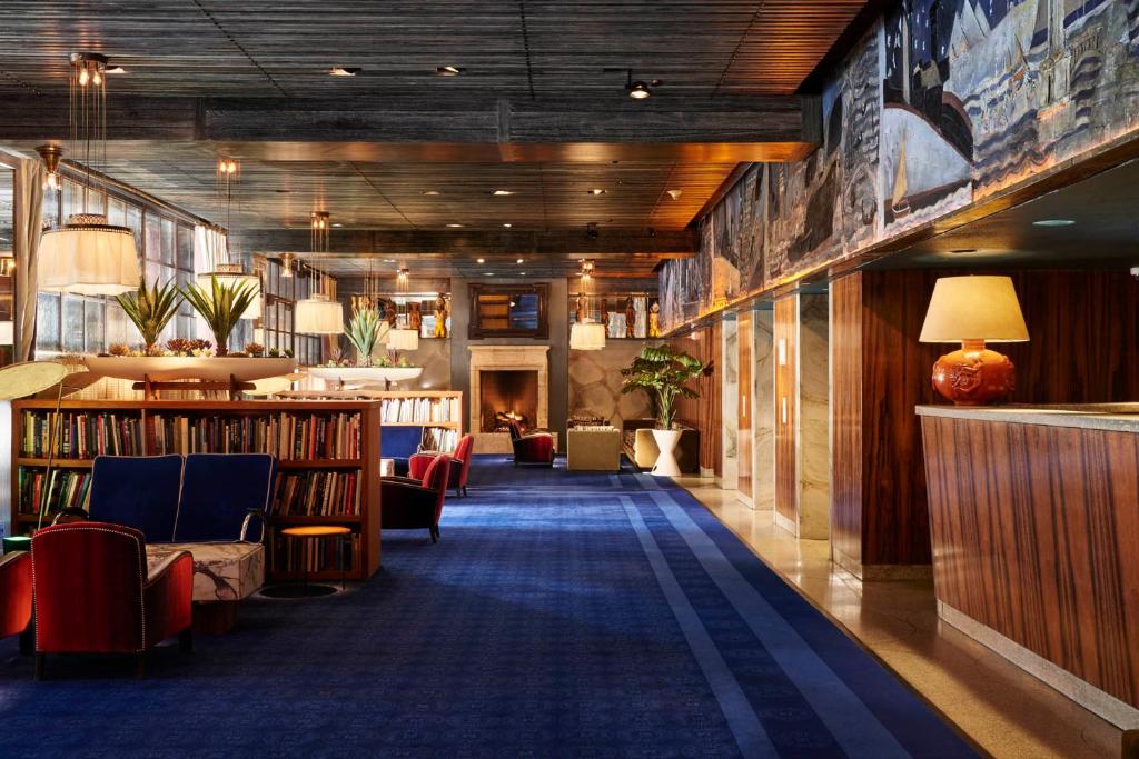 a library with couches and chairs and books at The Maritime Hotel in New York