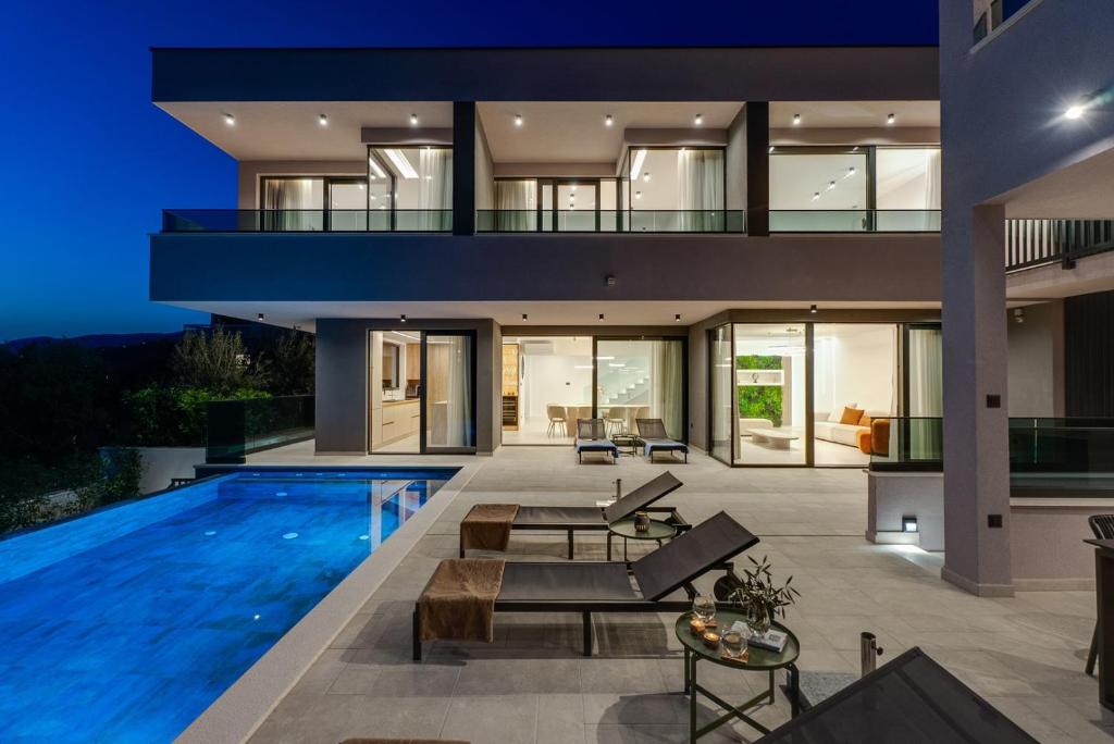 an exterior view of a house with a swimming pool at NEW! Villa Pavuza – Luxury 4-Bedroom Seaview Villa in Podstrana