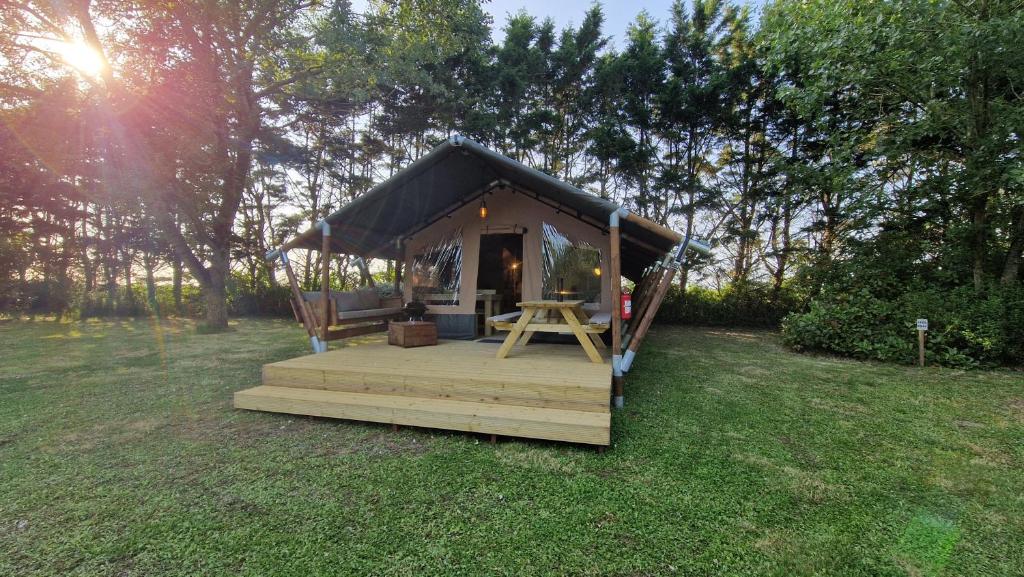 une petite cabine avec une terrasse en bois dans un champ dans l'établissement LODGE Premium, à Grues