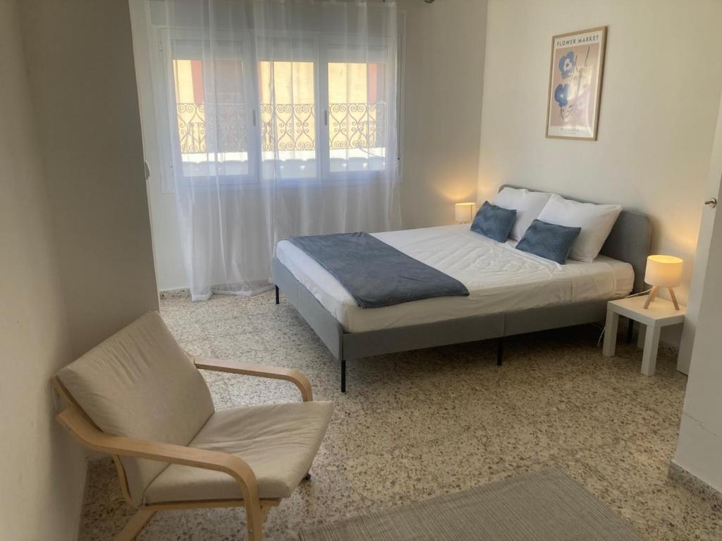 a bedroom with a bed and a chair at Apartamento Socorro in Ronda