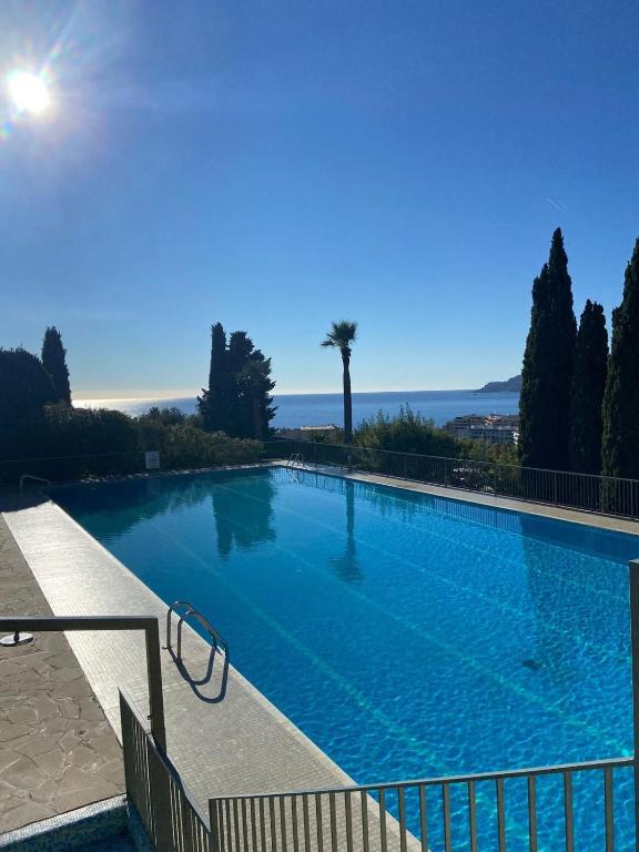 une grande piscine avec vue sur l'océan dans l'établissement Charmant studio avec piscine et jardin, à Cannes