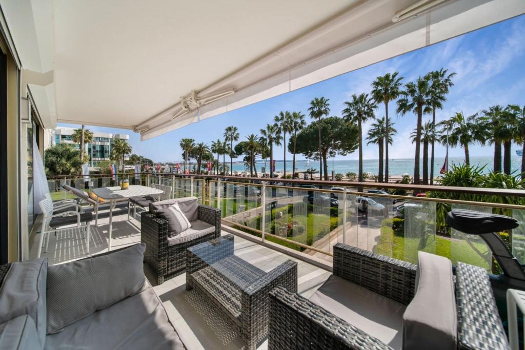 d'un balcon avec vue sur l'océan et les palmiers. dans l'établissement REF 1337 - Cannes Croisette - Sea view apartment for rent, à Cannes