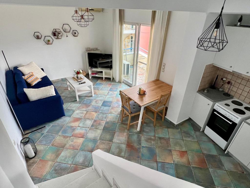 een woonkamer met een blauwe bank en een tafel bij Mountain View Apartment Lefkada in Apolpaina