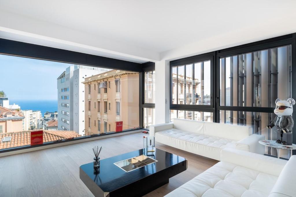 a living room with a white couch and a large window at Luxury 3BR Apartment with Sea View in Beausoleil