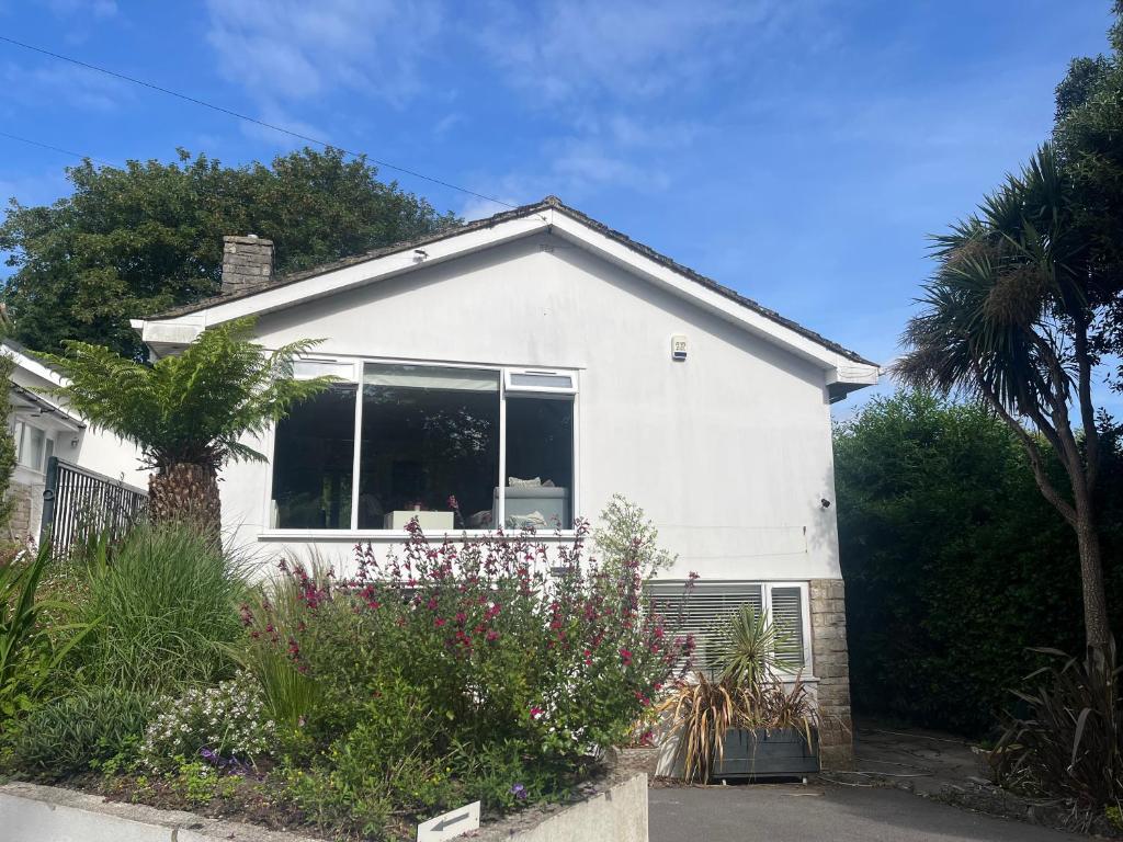 a white house with a window in a yard at Featured on Channel 4 with George Clarke with lazy spa in Bournemouth