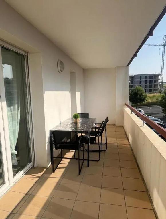 d'un balcon sur le toit avec une table et des chaises. dans l'établissement Appartement charmant à Hendaye, 41 m², proche plage, à Hendaye