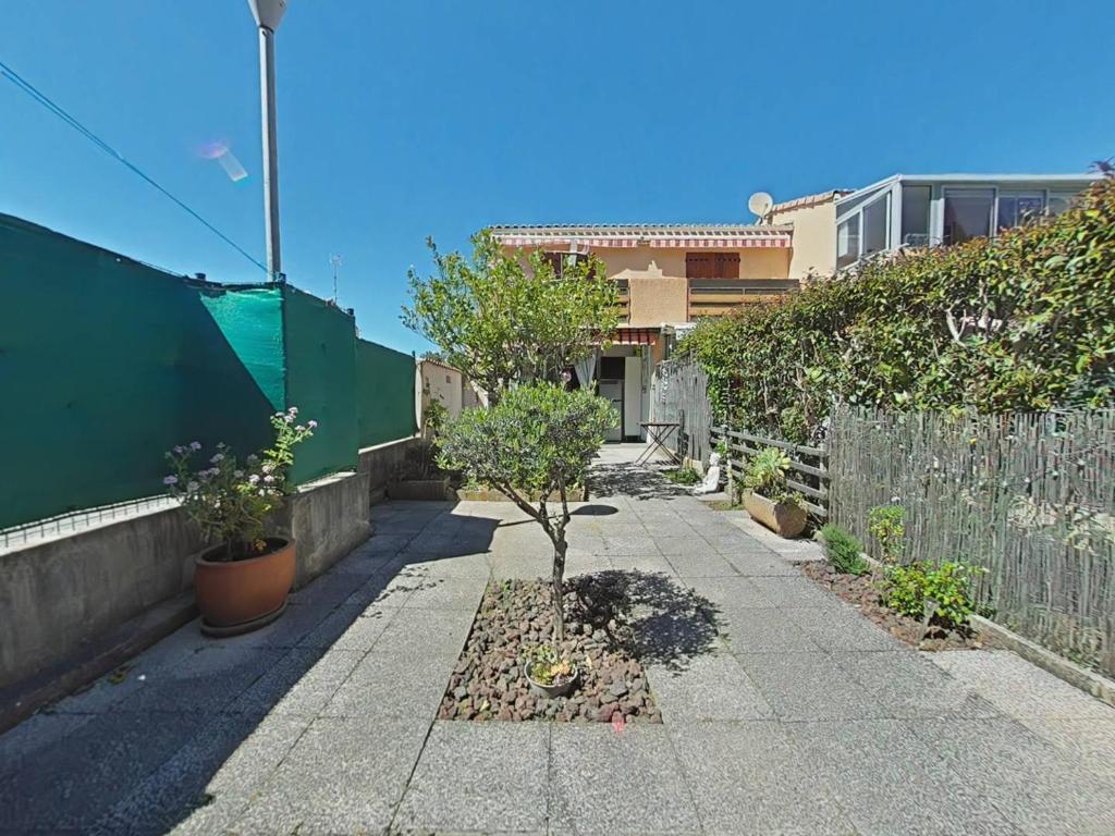 un trottoir avec un petit arbre dans une cour dans l'établissement La Londe Studio avec grande terrasse 4 pers LAL310-001, à La Londe-les-Maures