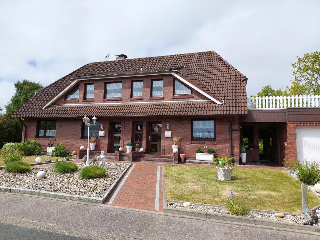a brown brick house with a brick driveway at Ferienwohnungen Sadtler Carolinensiel in Carolinensiel