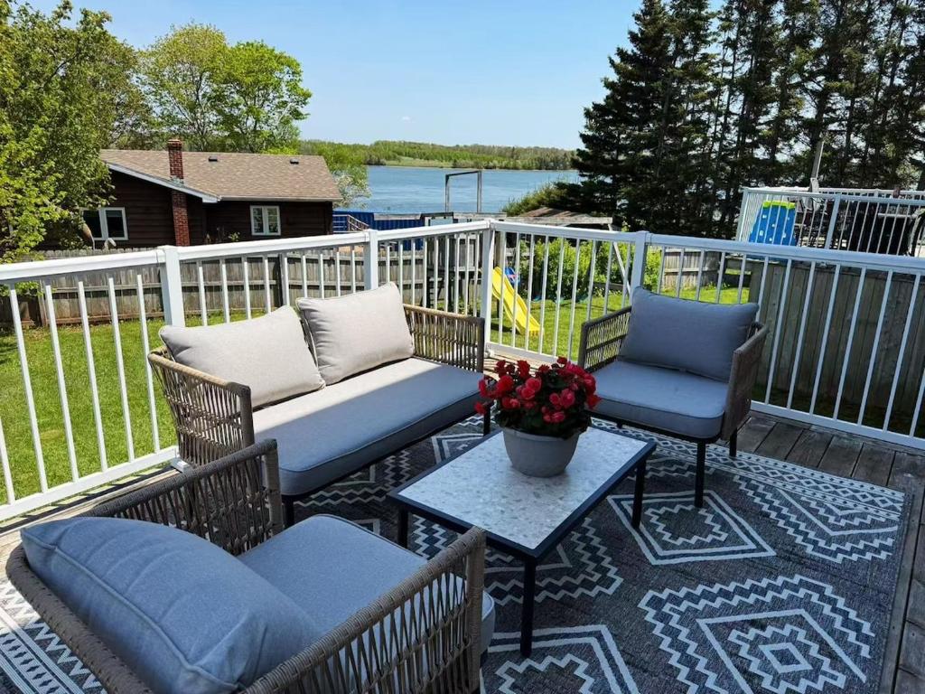 a patio with two chairs and a couch and a table at Tranquil Riverside Abode in Cornwall