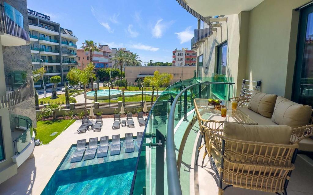 a balcony with a table and chairs and a pool at Qoople Legend A - Stylish accommodation by the sea in Alanya