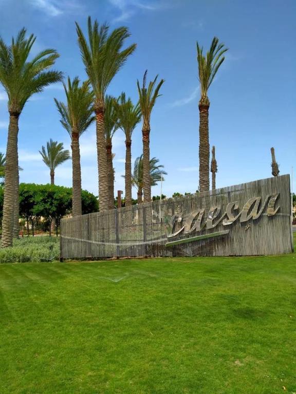 a fence in a park with palm trees at Caesar Sodic in Ras Elhekma