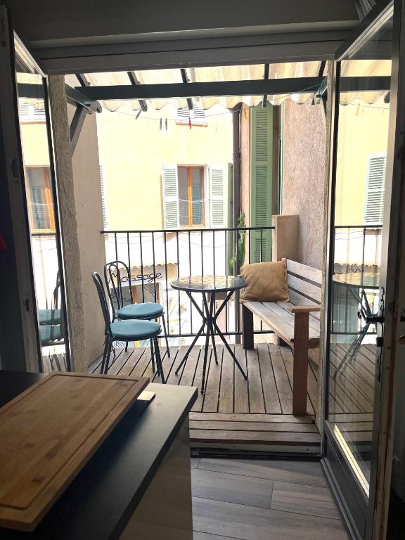 une véranda avec une table et un banc dans l'établissement Le rocher, à Antibes