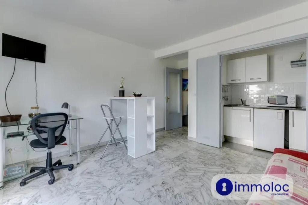 une cuisine avec une table et une chaise dans une pièce dans l'établissement Air-conditioned studio near the Promenade des Anglais, à Nice