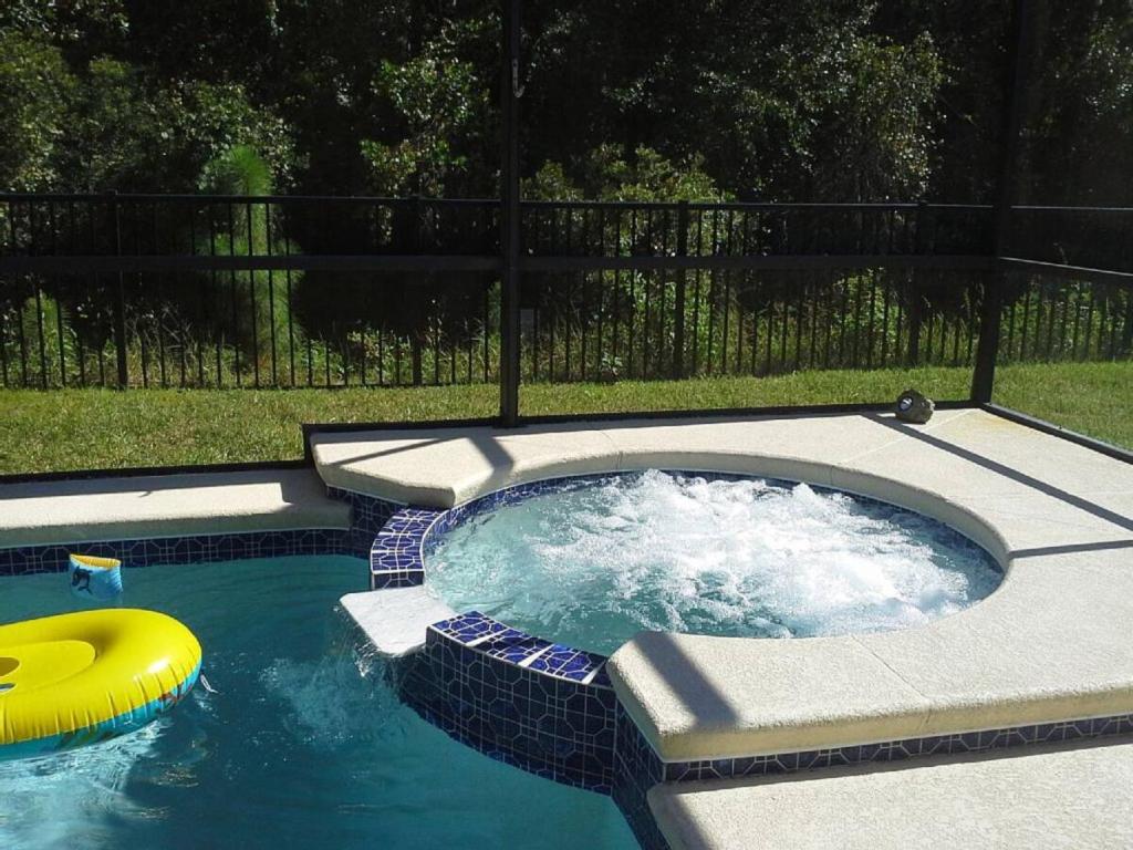 a hot tub with a yellow frisbee in a pool at The Hearth Home - 4 Suites in Kissimmee