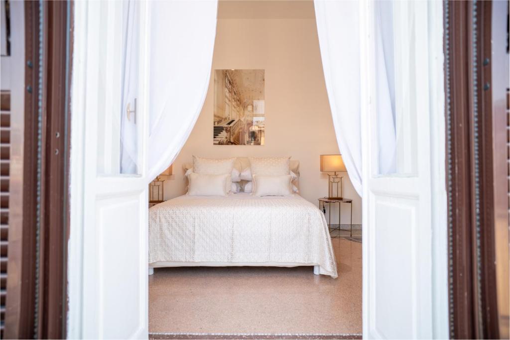 a bedroom with a white bed with white curtains at La Corte di Partenope Luxury Suite in Naples