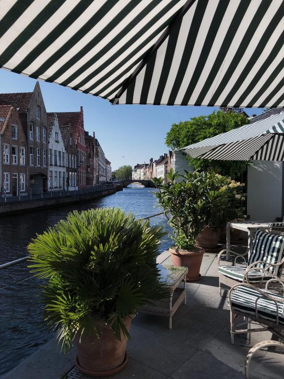 a view of a river from a patio with plants at Hotel Van Cleef in Bruges