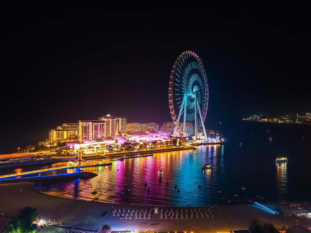 a ferris wheel in a city at night at Dubai Eye & Palm View #JBR Beach # ULTRA Luxurious 2 BHK in Dubai