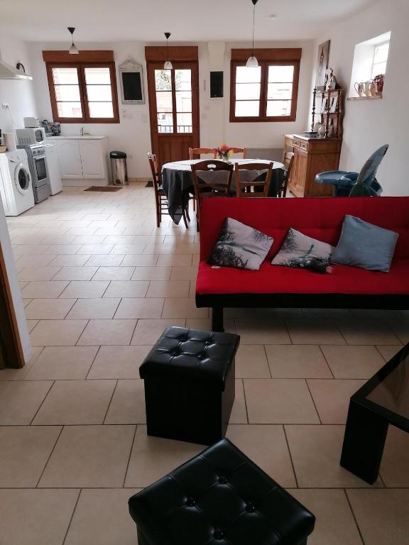 un salon avec un canapé rouge et une table dans l'établissement dans corps de ferme en Picardie, à Valines