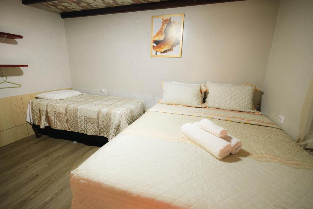 ein Schlafzimmer mit zwei Betten mit weißer Bettwäsche in der Unterkunft Hospedaria Camarão da ilha in Fernando de Noronha