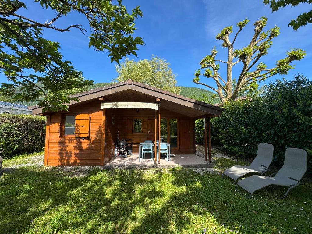 une petite cabine avec une table et des chaises dans l'herbe dans l'établissement Chalet Familial au bord du lac, à Doussard