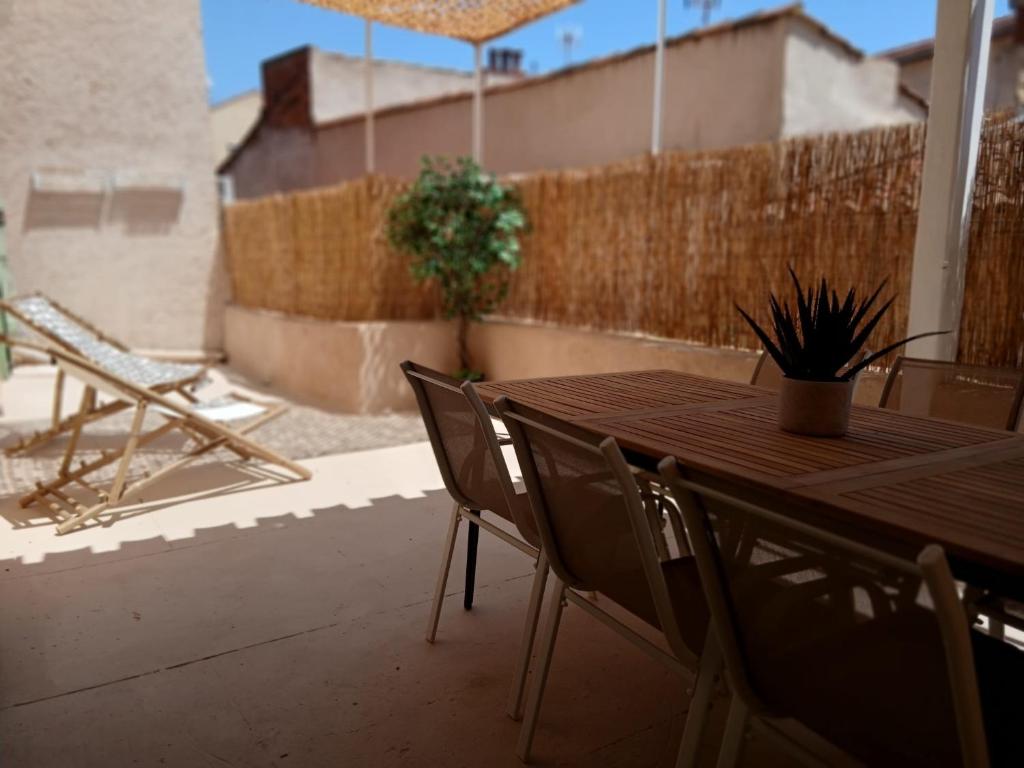 une table et des chaises en bois sur une terrasse dans l'établissement Très bel appartement refait à neuf dans la vieille ville de Hyères, 2 chambres, grande terrasse plein sud, à Hyères