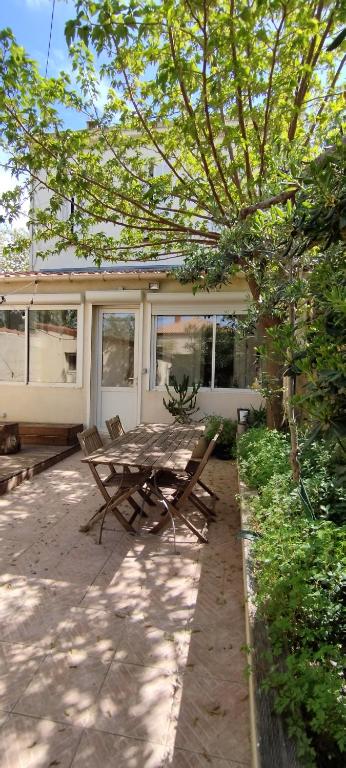 - une table de pique-nique et des chaises en face d'une maison dans l'établissement Location saisonnière Maison Pointe Rouge Marseille 8, à Marseille